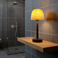 Modern shower lamp with warm light on wooden shelf in a tiled bathroom